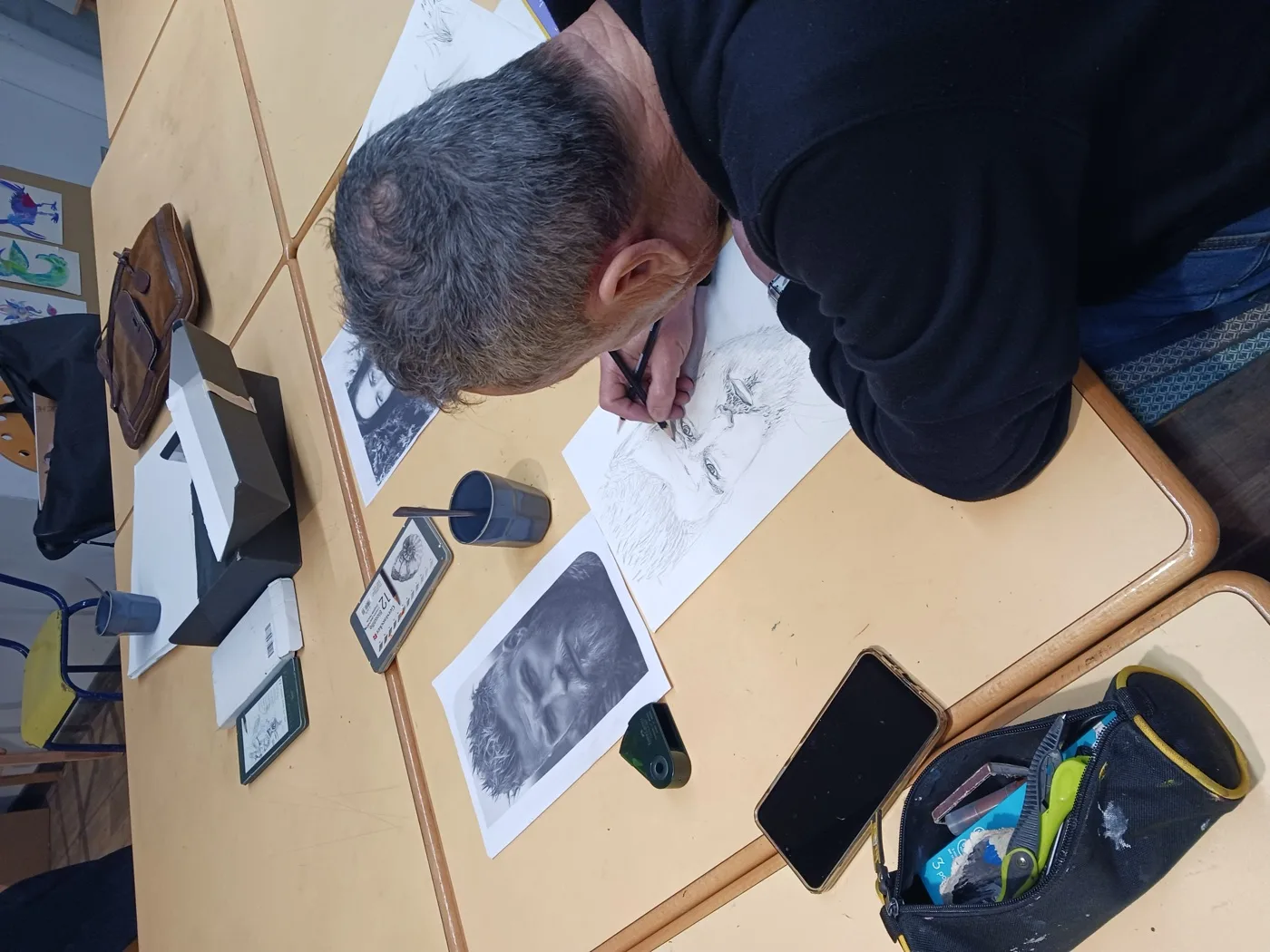 Élève dessinant un portrait au crayon